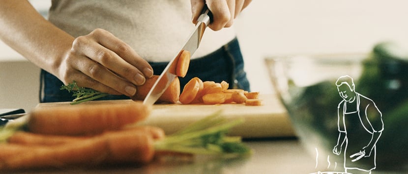 close-up of a person cutting carrots