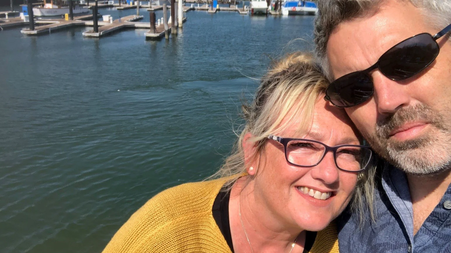 a man and woman taking a selfie by the water