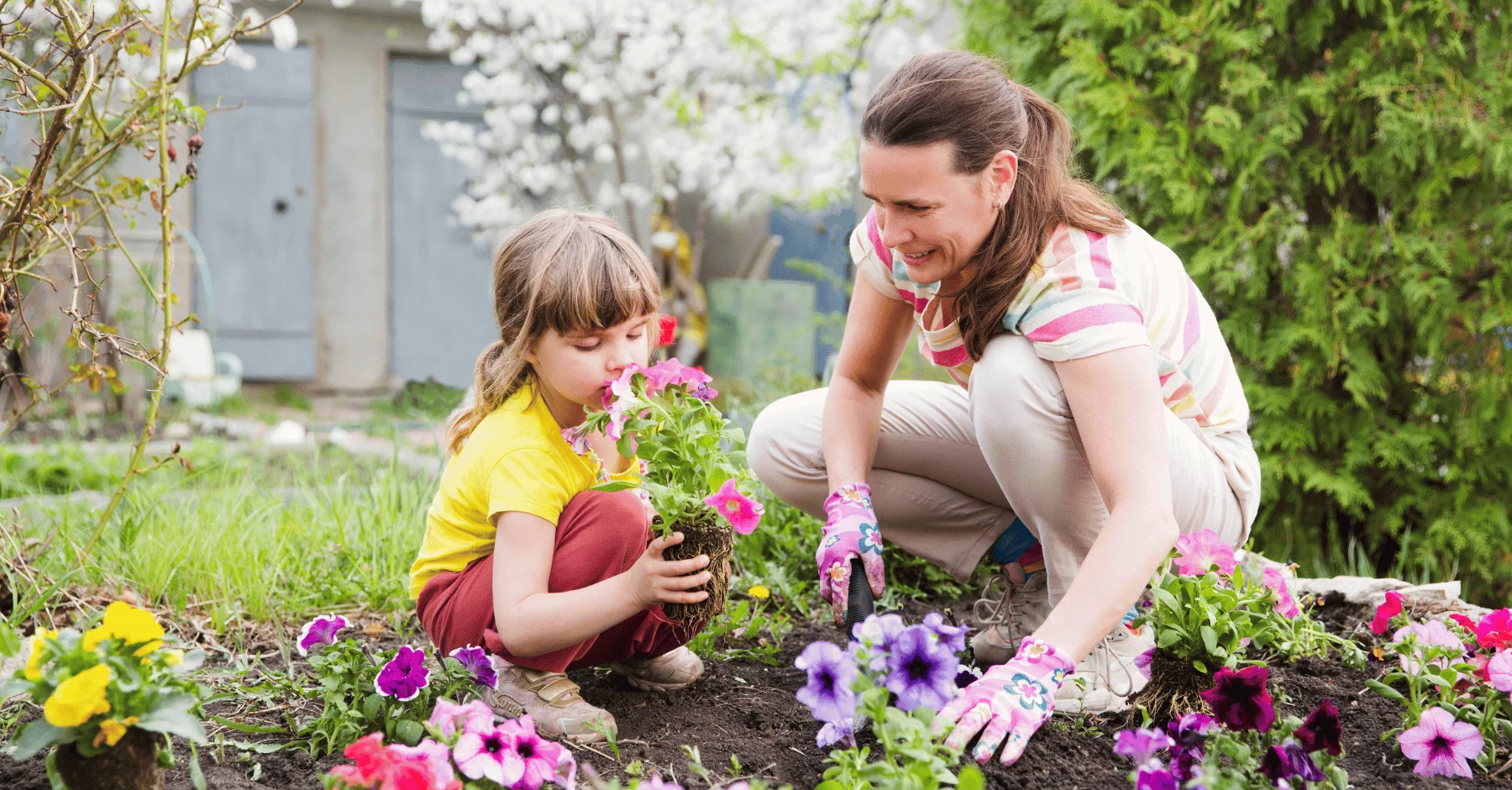 Člověk s dítětem klečící na zahradě