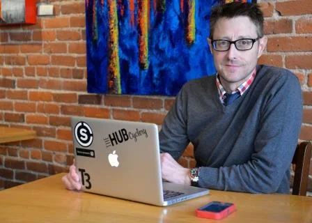 picture of man living with an ostomy posing with laptop 